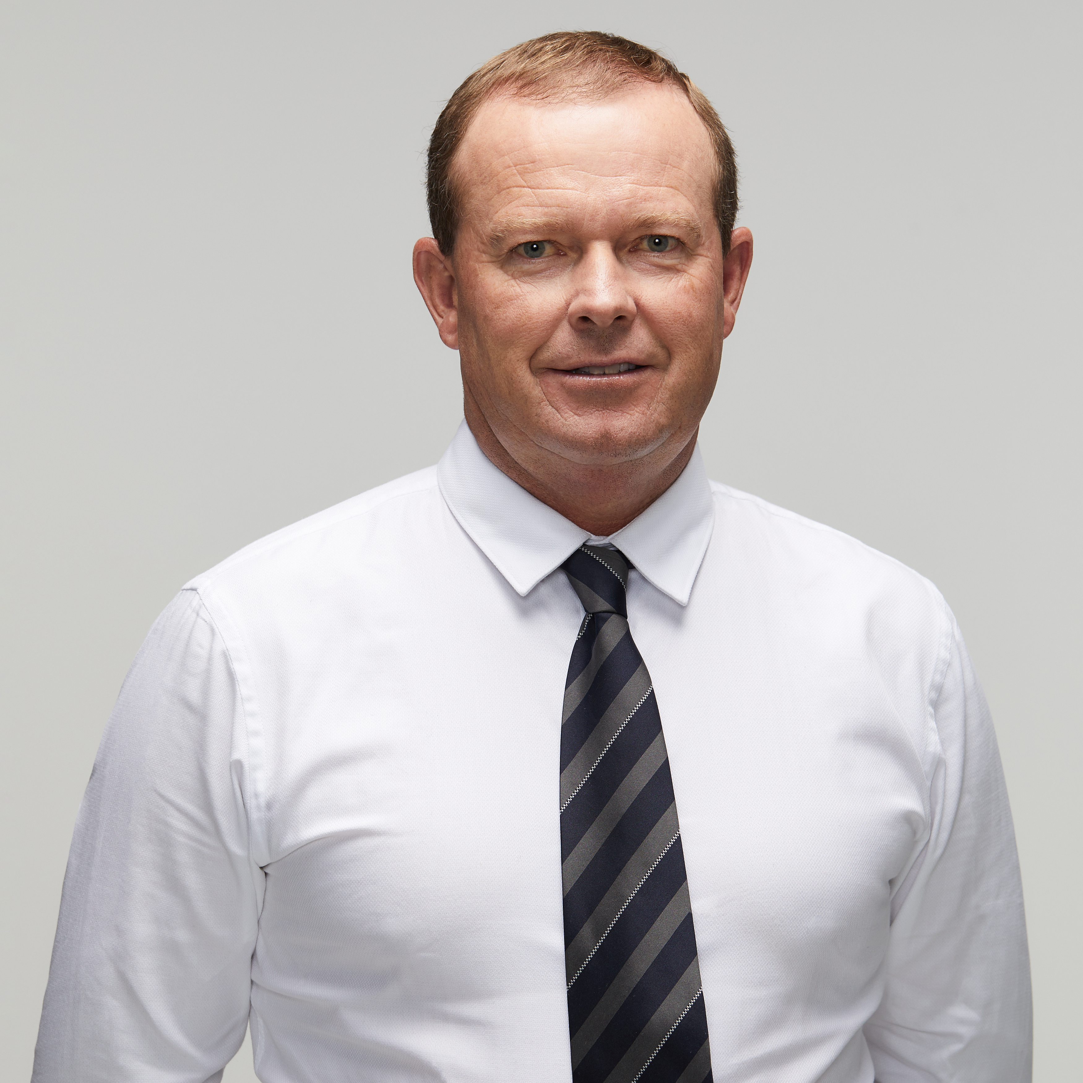 Peter B's story Image of current police officer looking at camera wearing white shirt with black and grey stripped tie; white male late thirties early forties