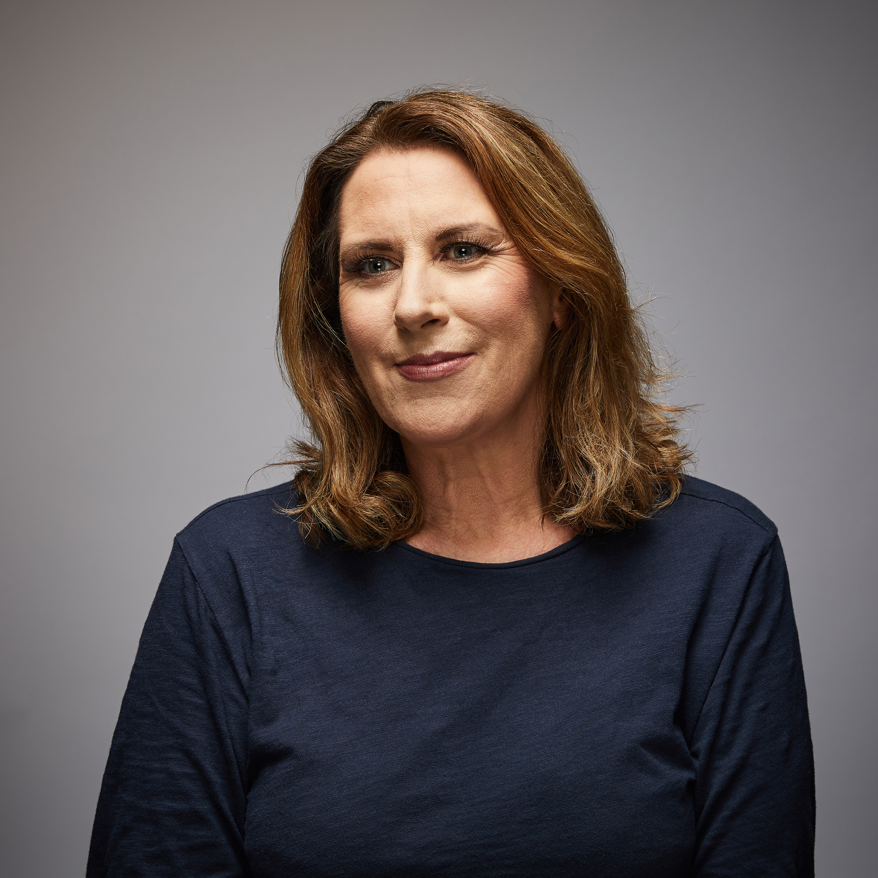 Rose's story Image of current police officer smiling to the left of camera wearing navy blue smart casual top. Late forties, female with light skin and shoulder-length light brown hair.